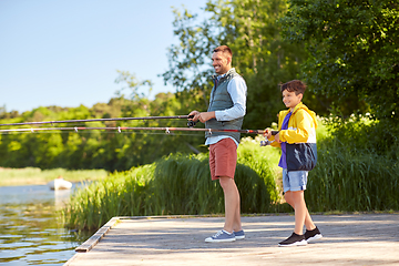 Image showing happy smiling father and son fishing on river