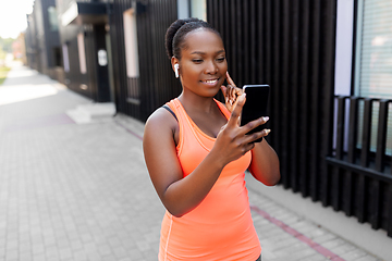 Image showing african american woman with earphones and phone