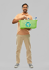 Image showing smiling young indian man sorting plastic waste