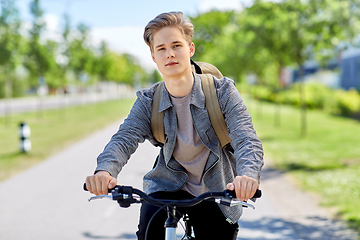 Image showing young man riding bicycle on city street