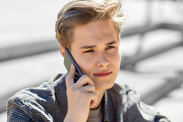 Image showing teenage boy calling on smartphone outdoors