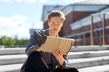 Image showing young man with notebook or sketchbook in city