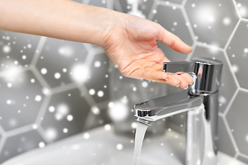 Image showing close up of woman's hand opening water tap