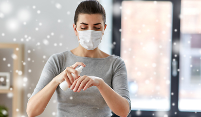 Image showing close up of woman in mask spraying hand sanitizer