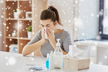 Image showing sick woman with medicine blowing nose to wipe