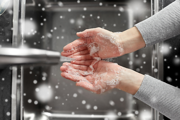 Image showing woman washing hands with soap in kitchen