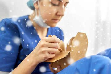 Image showing sad doctor or nurse eating takeaway food from box