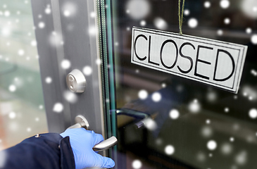 Image showing hand in medical glove holding to closed door