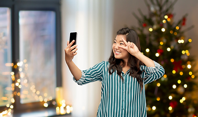 Image showing asian woman taking christmas selfie by smartphone