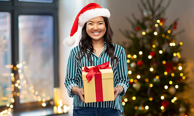 Image showing happy asian woman with christmas gift at home