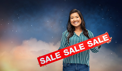 Image showing happy smiling young asian woman with sale banner