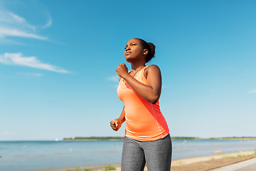 Image showing young african american woman running at seaside