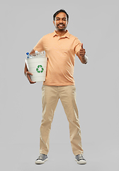 Image showing smiling young indian man sorting plastic waste