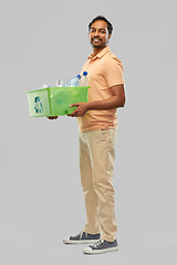 Image showing smiling young indian man sorting plastic waste