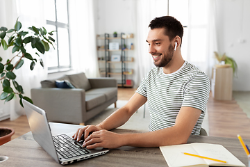 Image showing man with laptop and earphones at home office