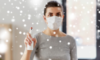 Image showing close up of woman in mask holding hand sanitizer