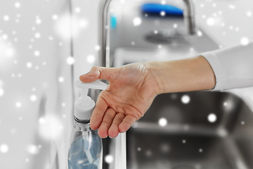 Image showing woman washing hands with liquid soap in kitchen