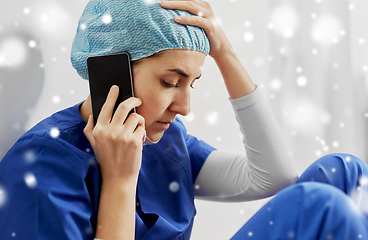 Image showing sad doctor or nurse calling on smartphone