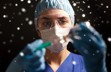 Image showing doctor in face mask with syringe and medicine