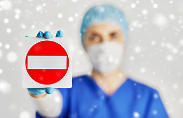 Image showing doctor or nurse in face mask showing stop sign