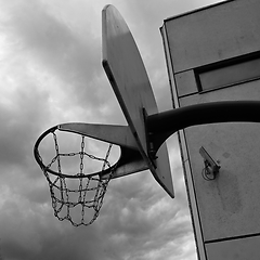 Image showing an anti-vandal basketball hoop with iron chains against a gloomy