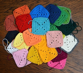 Image showing colorful knitted squares on the wooden background