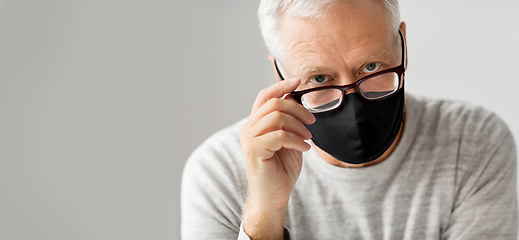 Image showing close up of senior man in glasses and black mask