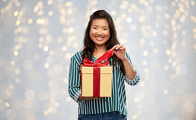 Image showing happy asian woman opening gift box