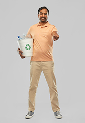 Image showing smiling young indian man sorting plastic waste