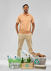 Image showing smiling man sorting paper, glass and plastic waste