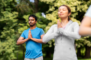 Image showing group of people doing yoga at summer park