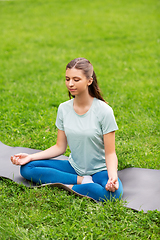 Image showing young woman meditating at summer park