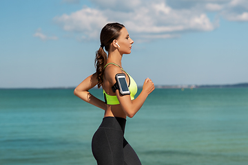 Image showing woman with earphones and smartphone running