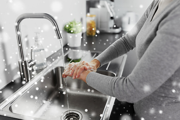 Image showing woman washing hands with liquid soap in kitchen