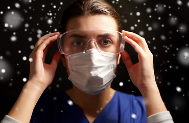 Image showing female doctor or nurse in goggles and face mask