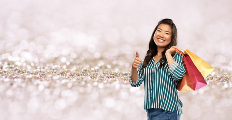 Image showing asian woman with shopping bags showing thumbs up