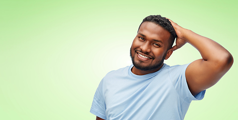 Image showing happy african american man touching his hair