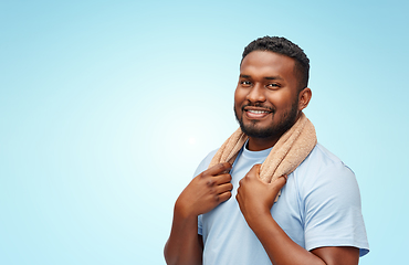 Image showing smiling african man with bath towel over blue