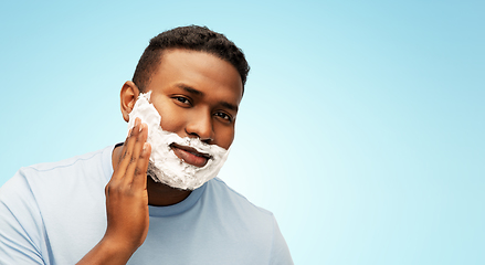 Image showing african american man applying shaving foam to face