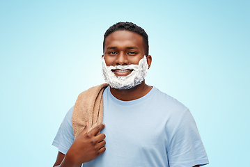 Image showing smiling african man with shaving cream and towel