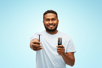 Image showing smiling african man with razor blade and trimmer