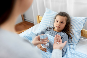 Image showing mother giving medicine to sick little daughter