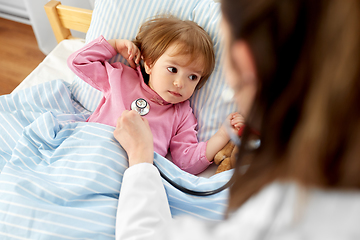 Image showing doctor with stethoscope and sick girl in bed