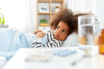 Image showing sick african american girl lying in bed at home