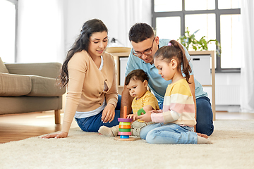 Image showing happy family playing with pyramid toy at home