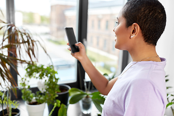 Image showing african american woman with smartphone at home