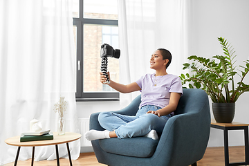 Image showing female blogger with camera video blogging at home