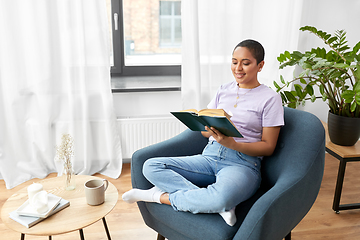 Image showing happy african american woman reading book at home