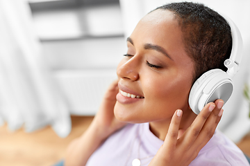 Image showing woman in headphones listening to music at home