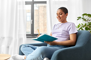 Image showing happy african american woman with diary at home